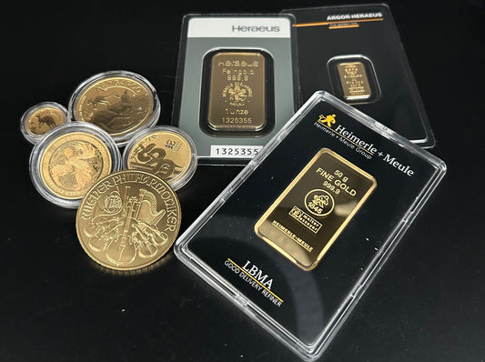 Goldbarren und Goldmünzen auf schwarzem Hintergrund